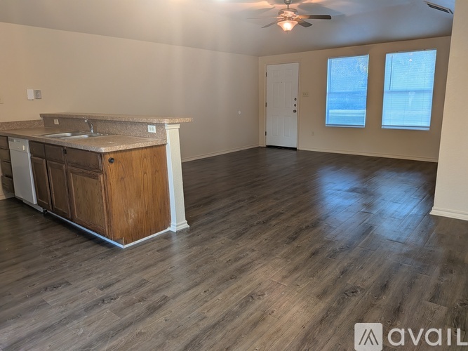 A spacious room with a kitchen island and wooden flooring.