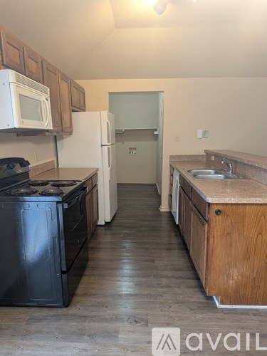 A kitchen with a black stove top oven and a white microwave above it.