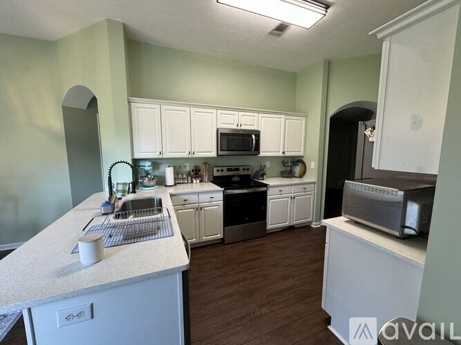 A kitchen with white cabinets and a white counter top.