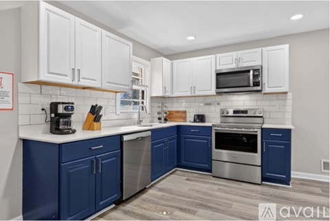 A kitchen with blue cabinets and stainless steel appliances.