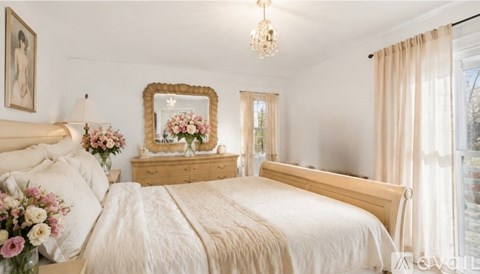 A bedroom with a large bed and a chandelier.