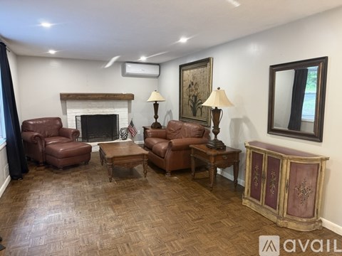 A living room with brown leather furniture and a fireplace.