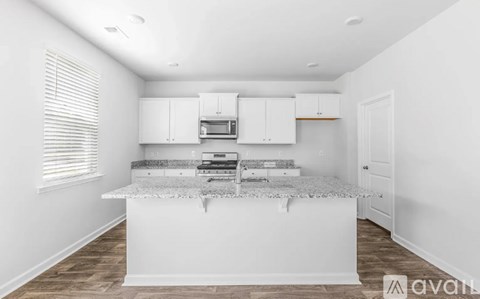 A kitchen with white cabinets and a granite countertop.