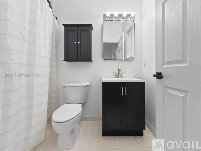 A bathroom with a toilet, sink, and medicine cabinet.