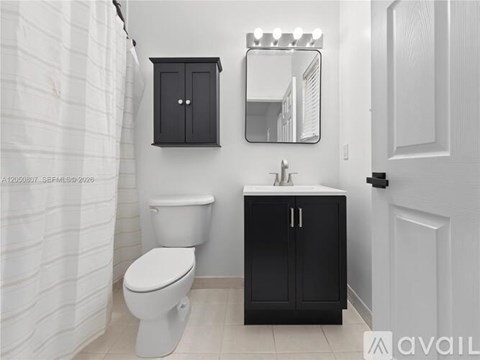 A bathroom with a toilet, sink, and medicine cabinet.