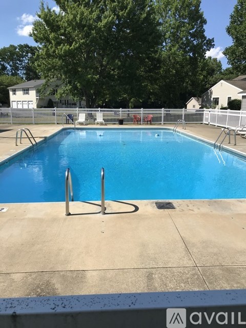 A pool with a blue water and a white fence around it.