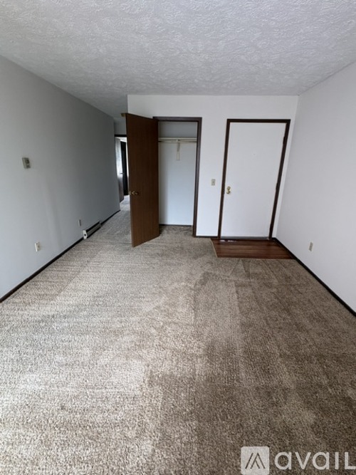 A carpeted hallway with two doors and a window.
