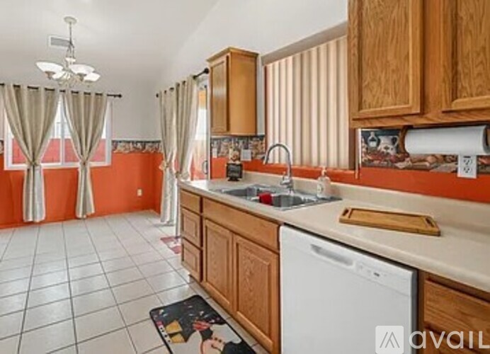 A kitchen with wooden cabinets and a white dishwasher.