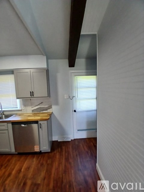 A kitchen with wooden floors and white walls.