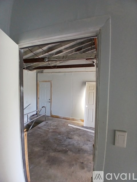 A room with a white door and a window with a white wall.