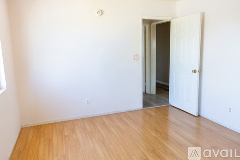 A room with a wooden floor and a door on the right.