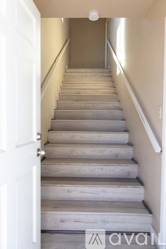 A set of stairs with a white door on the left.