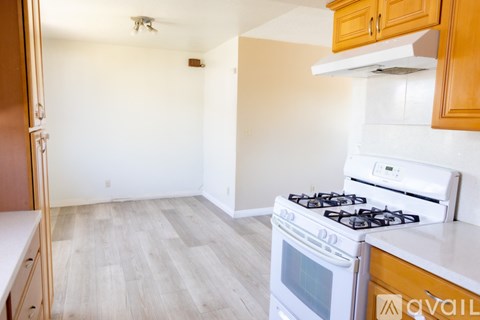 A kitchen with a white stove top oven and a white microwave.