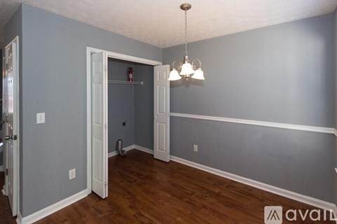 A room with a grey wall and a white door.