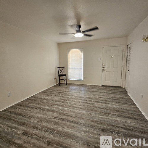 A room with a wooden floor and a ceiling fan.