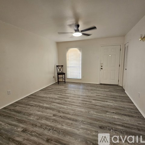 A room with a wooden floor and a ceiling fan.