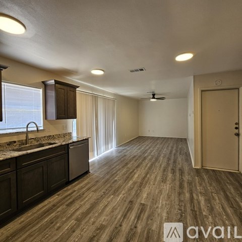 A kitchen with dark wood cabinets and a marble countertop.