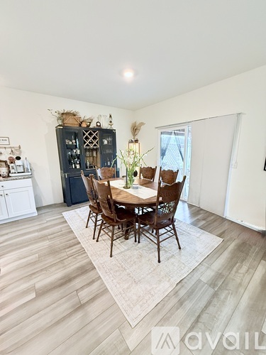 A dining room with a wooden table and chairs.