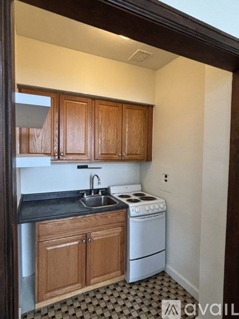 A kitchen with wooden cabinets and black countertops.