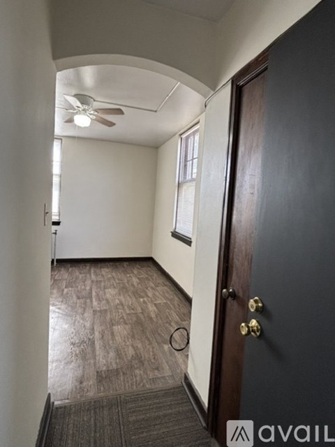 A room with a ceiling fan and a door.