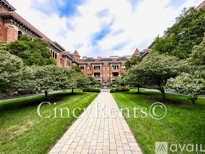 A pathway leads to a large building with a brick facade.