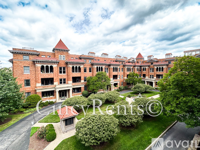 A large red brick building with a clock tower and a sign that says City Rents.