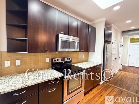 A kitchen with brown cabinets and a stove top oven.