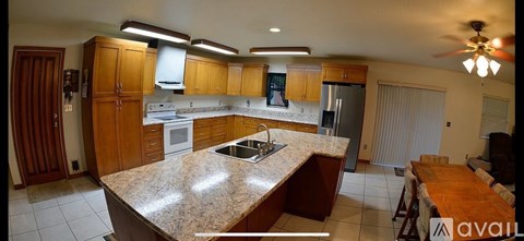A kitchen with wooden cabinets and a granite countertop.