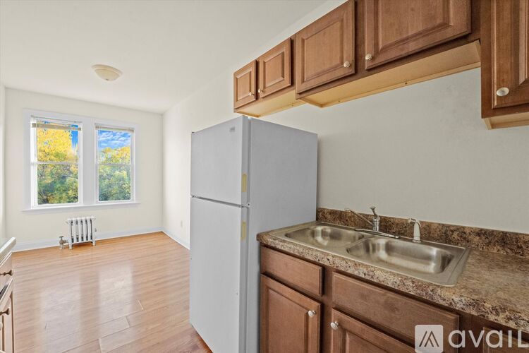 A kitchen with a white fridge and wooden cabinets.