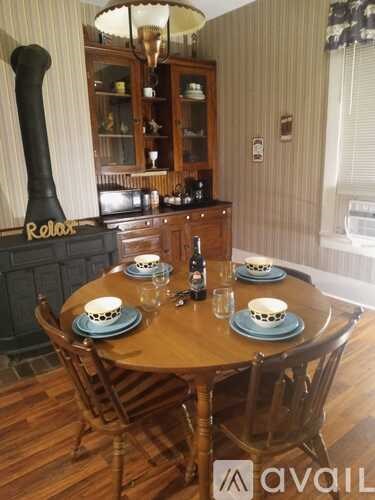 A dining room with a wooden table set for four.