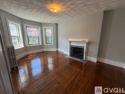 A room with wood floors and a fireplace.