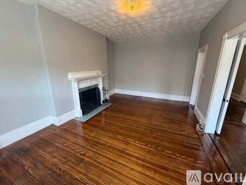 A room with a fireplace and wood flooring.