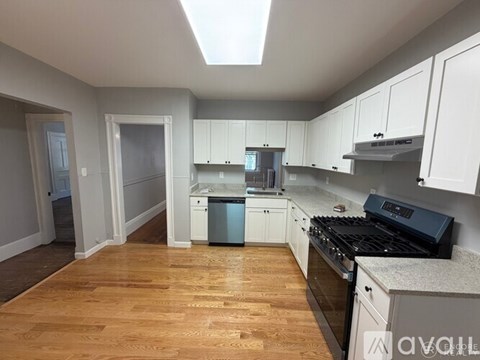 A kitchen with white cabinets and a black stove top oven.