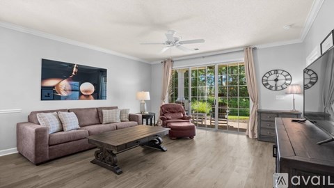 A living room with a brown couch, a wooden coffee table, and a painting on the wall.