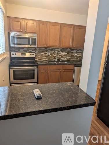 A kitchen with a granite countertop and a stove top oven.