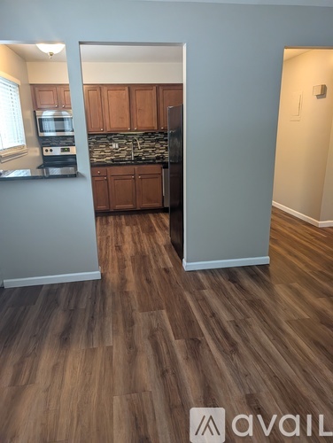 A kitchen with wooden floors and cabinets.