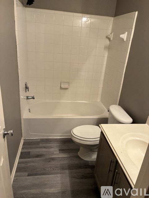 A bathroom with a toilet, sink, and bathtub.