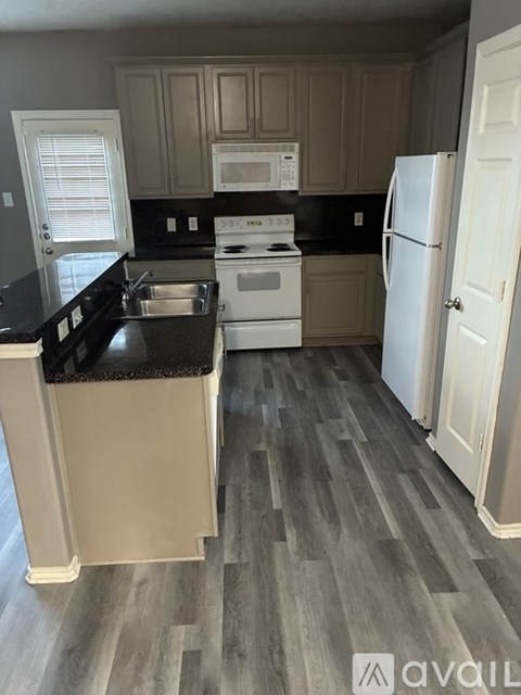 A kitchen with a white stove top oven and a white refrigerator.