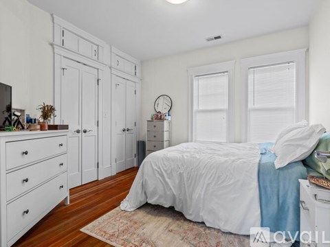 A bedroom with a bed, dresser, and wardrobe.