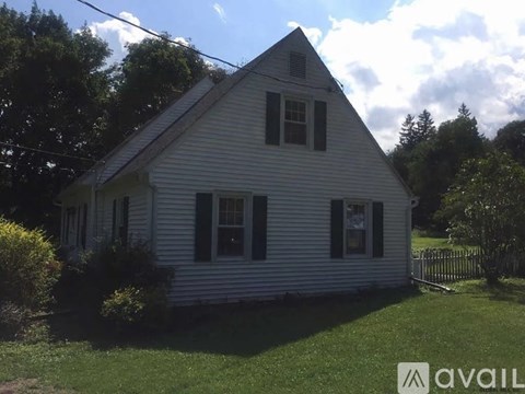 A white house with a black window is for sale.
