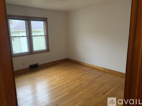 A room with wooden flooring and a window.