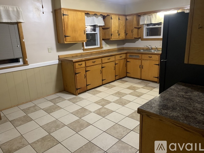 A kitchen with wooden cabinets and a checkered floor.