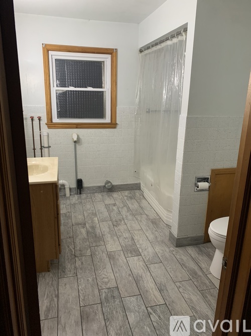 A bathroom with a toilet, sink, and shower.