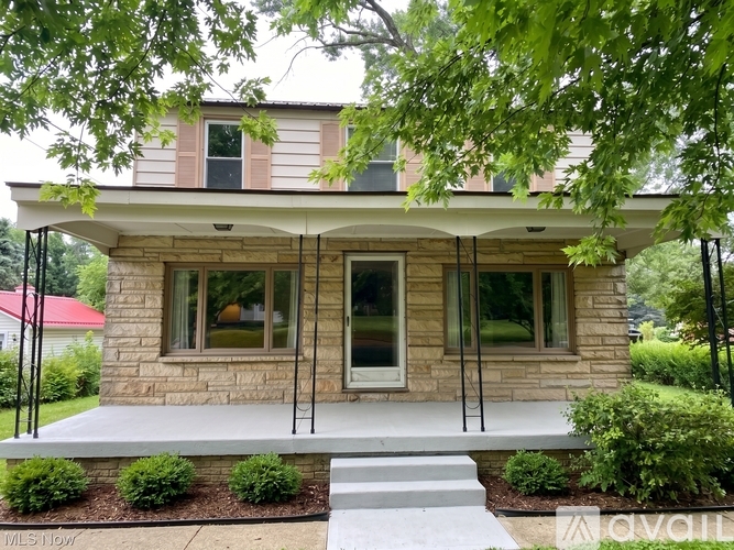 A house with a red roof and a porch.