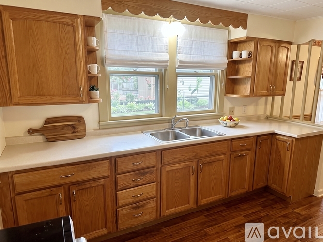 A kitchen with wooden cabinets and a window.