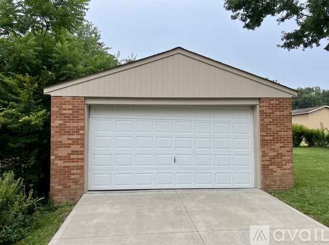 A two-car garage with a brick pillar and a metal roof.