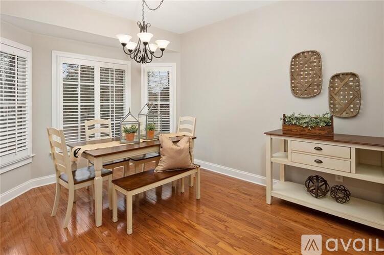 A dining room with a wooden table and chairs.