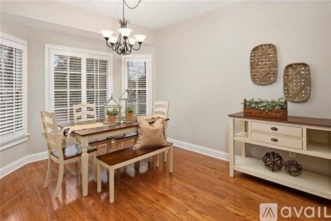 A dining room with a wooden table and chairs.