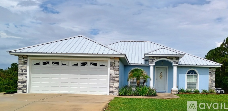 A house with a blue exterior and a white garage door.