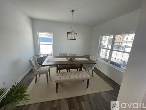 A dining room with a table and chairs.